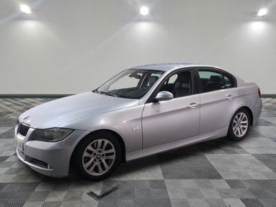 Une BMW Série 3 berline de 2011 dans un showroom au sol à damier