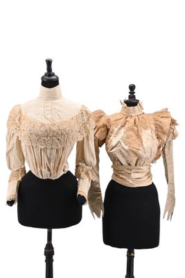 two mannequins with dresses on display on a white background