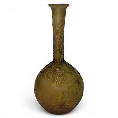 a green glass vase with a floral design on it