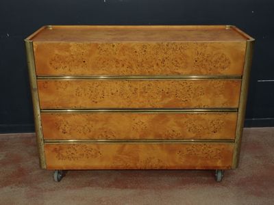 une image représentant une commode en bois à quatre tiroirs montée sur roulettes