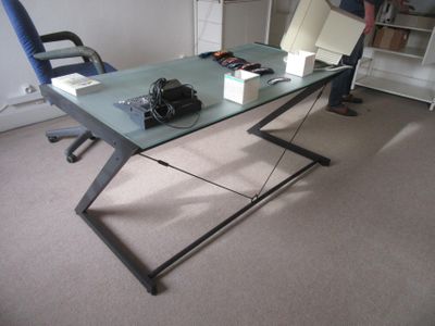 a man standing in front of a desk with a laptop on it