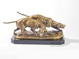 une statue en bronze représentant deux chiens, posée sur un socle en marbre