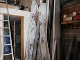 a room with a ladder, a ladder, and a pile of pipes