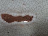 a close up of a white plate with a rusted edge