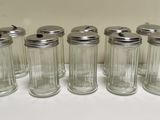 six glass jars with lids are lined up on a white surface
