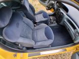 a yellow car with black seats in the back of it