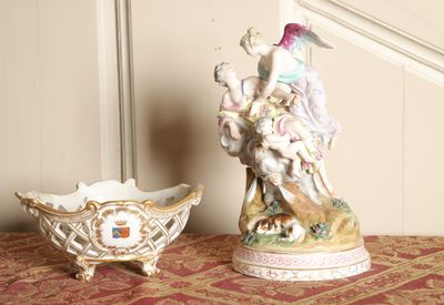 two figurines sitting on a table next to a bowl