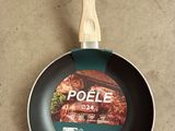 a frying pan with a wooden handle sitting on a counter