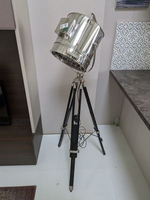une lampe posée sur un trépied près d'une cheminée
