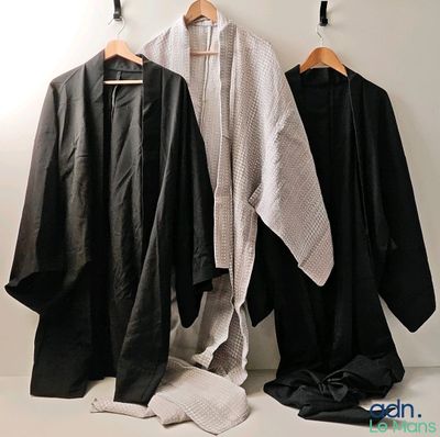 three black and white robes hanging on a wall