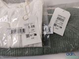 a white sweater and a green sweater with a price tag on it