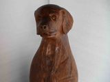 a wooden statue of a dog that is sitting on a table