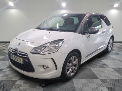 la petite voiture blanche est garée sur un sol en damier