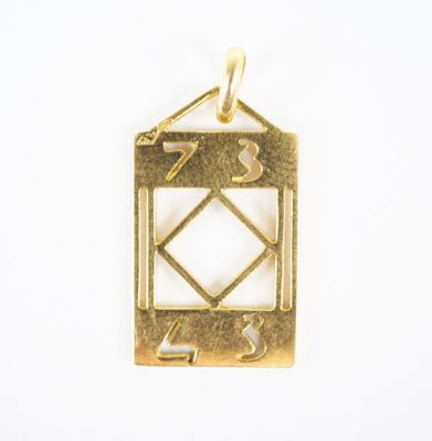 a close up of a gold pendant with a diamond in the middle