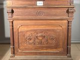 a wooden cabinet with carvings on it in a room