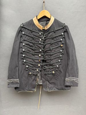 une vieille veste militaire accrochée au mur à un cintre en bois