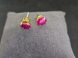 une paire de boucles d'oreilles roses posées sur un oreiller