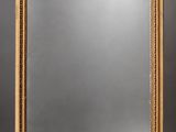 a large antique mirror with a gold frame and ornate decoration