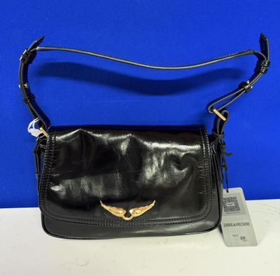 un sac à main en cuir noir orné d'un oiseau doré sur le devant