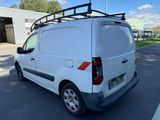 the white van is parked in the parking lot with its roof rack on