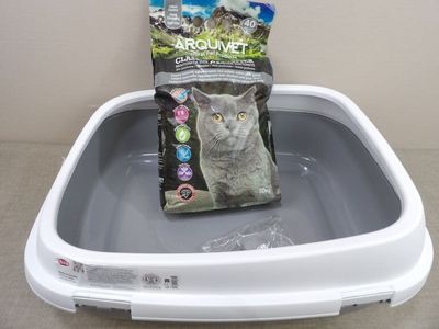 un sac de nourriture pour chat posé sur un bac à litière