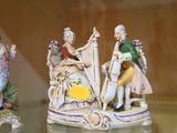 quatre figurines représentant des personnes assises sur une table en verre