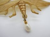 broche en forme d'insecte plaquée or, ornée d'une perle sur fond blanc