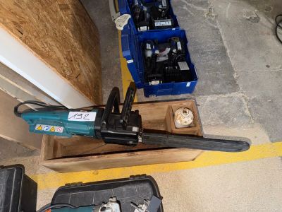 une photo d'une tronçonneuse et d'outils dans un garage