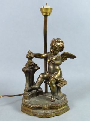 lampe en laiton plaqué représentant un ange tenant un oiseau et une lampe posée sur un socle