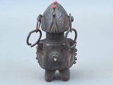 une petite statue représentant un robot avec une perle rouge sur la tête