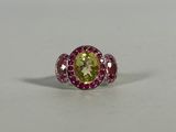 a ring with a yellow and pink stone surrounded by pink sapphires