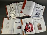 several books with drawings and pictures of people on them sitting on a table