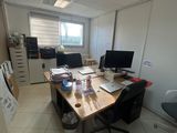 une photo d'une pièce avec un bureau et deux écrans