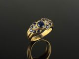 an image of a gold ring with blue sapphires