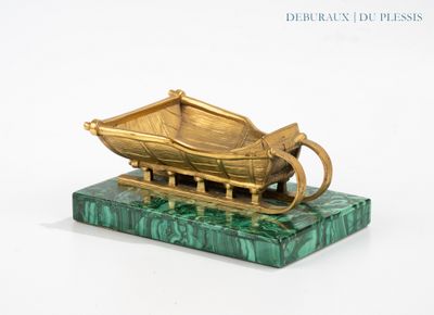 a gold boat on a green marble base