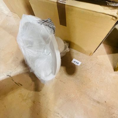 a white umbrella sitting on the floor next to a box