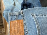 plusieurs paires de jeans sont empilées les unes sur les autres