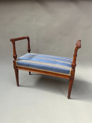 une photo d'un banc avec un coussin rayé bleu et blanc