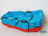 a blue and red kayak sitting on a white surface