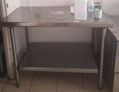 une table en métal sur laquelle est posée une bouteille d'eau