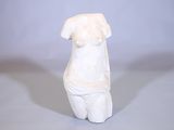 une statue blanche représentant une femme assise sur une table