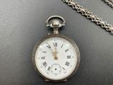 a silver pocket watch with roman numerals on it