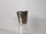 a silver cup sitting on a clear table