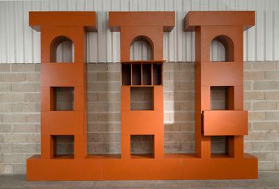 deux bibliothèques orange placées contre un mur de briques
