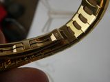 a person holding a gold watch in their hand