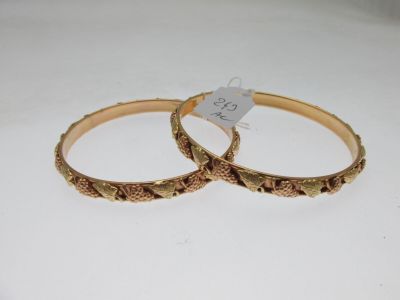 pair of gold tone bangles with engraved design