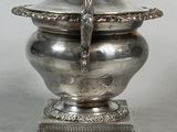 a silver container with a bird on top of it
