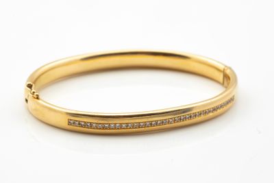 Bracelet jonc ovale ouvrant serti d’une lignée de petits dia…