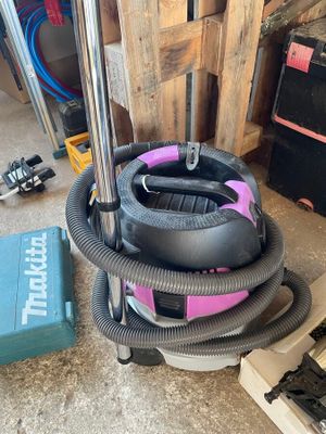 un aspirateur posé par terre à côté d'une boîte à outils