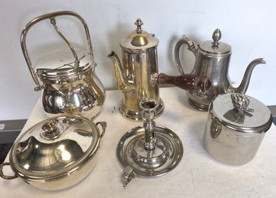 de nombreuses théières et cafetières en argent posées sur une table